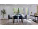 Dining room features wood table, six chairs, a patterned rug, and three windows with view at 5190 Potters Pike, Indianapolis, IN 46234