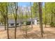 Beautiful view of a two-story home with a black roof, black trim, and surrounded by woods at 5190 Potters Pike, Indianapolis, IN 46234