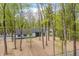 Scenic view of a two-story home featuring a modern exterior, black roof, black trim, and wooded lot at 5190 Potters Pike, Indianapolis, IN 46234