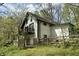 Exterior view of a white home surrounded by lush greenery and a rustic wooden fence at 5190 Potters Pike, Indianapolis, IN 46234