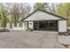 Garage exterior with modern black garage door and white brick, surrounded by a landscaped yard and greenery at 5190 Potters Pike, Indianapolis, IN 46234