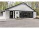 Garage exterior with modern black garage door and white brick, address detail, and surrounding landscaped yard at 5190 Potters Pike, Indianapolis, IN 46234