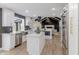 Open concept kitchen featuring white cabinets, stainless steel appliances, and light wood flooring at 5190 Potters Pike, Indianapolis, IN 46234