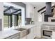 Kitchen with stainless steel appliances, white cabinets, and a farmhouse sink overlooking the deck at 5190 Potters Pike, Indianapolis, IN 46234