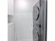 Modern stacked washer and dryer unit with white cabinets in a bright and clean laundry area at 5190 Potters Pike, Indianapolis, IN 46234