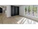 Living room featuring light wood floor, large window with wood trim, and built-in bookcase at 5190 Potters Pike, Indianapolis, IN 46234