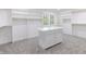 Bright walk-in closet with white cabinets, shelving, and center island at 5190 Potters Pike, Indianapolis, IN 46234