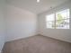An empty bedroom with neutral carpeting and a large window offers a blank canvas for personalization at 5204 Cartland Dr, Indianapolis, IN 46239