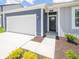 Close up of a single-story home with blue and gray siding, white garage door, green lawn and trimmed hedges at 5204 Cartland Dr, Indianapolis, IN 46239