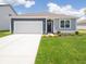 Charming single-story home with a blue and gray exterior, a white garage door and a well-maintained front lawn at 5204 Cartland Dr, Indianapolis, IN 46239