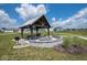 Community picnic shelter with table, seating, fire pit, grill, and a view of the neighborhood pond at 5204 Cartland Dr, Indianapolis, IN 46239