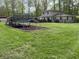 A well-manicured backyard featuring a play area, lush green lawn, and mature trees at 5282 W Blue Bell Dr, New Palestine, IN 46163