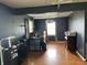 A bedroom with hardwood floors, a large window, and medical equipment next to the bed at 5282 W Blue Bell Dr, New Palestine, IN 46163