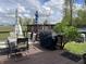 Inviting deck area with a grill, an umbrella-covered table, and seating near the backyard at 5282 W Blue Bell Dr, New Palestine, IN 46163