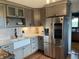 Modern kitchen featuring stainless steel appliances, farmhouse sink, and stylish gray cabinetry at 5282 W Blue Bell Dr, New Palestine, IN 46163