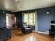 Cozy living room featuring hardwood floors, a recliner, and an inviting bay window at 5282 W Blue Bell Dr, New Palestine, IN 46163