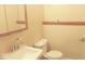 Compact bathroom featuring a sink, toilet, and vanity mirror at 5415 Wagon Wheel Trl, Indianapolis, IN 46237