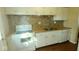 Functional kitchen with white cabinetry, laminate countertop, and neutral tiled backsplash at 5415 Wagon Wheel Trl, Indianapolis, IN 46237