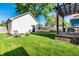 A beautifully landscaped backyard features a lush lawn, wooden pergola with lights and outdoor seating at 544 N Beville Ave, Indianapolis, IN 46201