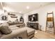 Cozy basement living room with a large sectional sofa, modern entertainment center, and light wood floors at 544 N Beville Ave, Indianapolis, IN 46201