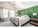 A bright bedroom features a large bed, two windows, and a dark green accent wall at 544 N Beville Ave, Indianapolis, IN 46201