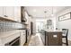 A modern kitchen features an island with seating, stainless steel appliances, decorative backsplash and a light-filled breakfast area at 544 N Beville Ave, Indianapolis, IN 46201