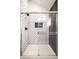 Modern shower stall with white subway tile in a herringbone pattern and glass door, highlighted by sleek black hardware at 544 N Beville Ave, Indianapolis, IN 46201