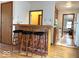 Home bar with three stools providing a view into the kitchen and living areas at 5450 E 18Th St, Indianapolis, IN 46218