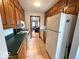 Galley kitchen with oak cabinets, white appliances, and an open view into the living room at 5450 E 18Th St, Indianapolis, IN 46218