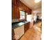Kitchen with wood cabinets, white appliances, and a double basin sink under a window at 5450 E 18Th St, Indianapolis, IN 46218