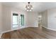 Bright dining area with hardwood floors, modern chandelier, and french doors leading to the outdoors at 5548 Painted Maple Ct, Indianapolis, IN 46254