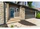 Close-up of a home with stone details, a blue front door, and an attached garage at 5548 Painted Maple Ct, Indianapolis, IN 46254