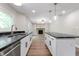 Modern kitchen with dark countertops, white cabinets, stainless steel appliances, and a view to the fireplace at 5548 Painted Maple Ct, Indianapolis, IN 46254
