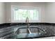 Close up on kitchen sink with stainless steel fixtures and a view from the window overlooking nature at 5548 Painted Maple Ct, Indianapolis, IN 46254