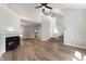 Open-concept living room with a fireplace, hardwood floors, and a staircase at 5548 Painted Maple Ct, Indianapolis, IN 46254