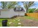 Backyard with stone path leading to the white sided house with an upper window and an adjoined garage at 555 S Auburn St, Indianapolis, IN 46241