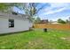 Fenced-in backyard with a stone path leading to a white house with an adjoined white garage under a cloudy sky at 555 S Auburn St, Indianapolis, IN 46241