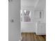 Bathroom features wood floors, a shower, a single sink, mirror, and a large window looking onto a large tree at 555 S Auburn St, Indianapolis, IN 46241