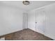 A bedroom with neutral carpet and white walls, closet with bifold doors, and a standard paneled door at 555 S Auburn St, Indianapolis, IN 46241