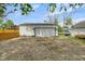 A white garage with two lights over the garage door and an open gravel area in front at 555 S Auburn St, Indianapolis, IN 46241