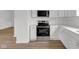 A well-lit kitchen area with modern stainless steel stove and microwave, white cabinets, and wood floors at 555 S Auburn St, Indianapolis, IN 46241