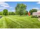 Expansive backyard features a play set, lush green lawn, and privacy fence, creating an ideal space for outdoor activities at 5617 Gainesway Dr, Greenwood, IN 46142