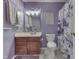 Purple bathroom featuring a cherrywood vanity, mirror, toilet and a shower with a decorative shower curtain at 5617 Gainesway Dr, Greenwood, IN 46142