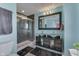 Modern bathroom with a glass shower, double sink vanity, black framed mirror and light-blue colored walls at 5617 Gainesway Dr, Greenwood, IN 46142