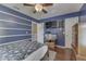 Blue bedroom with shelving, hardwood floors, a ceiling fan, a flat-screen television and a fish tank at 5617 Gainesway Dr, Greenwood, IN 46142