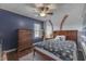 Blue bedroom with a baseball theme, hardwood floors, a ceiling fan and a tall chest-of-drawers at 5617 Gainesway Dr, Greenwood, IN 46142