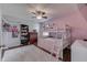 Pink themed bedroom with a bunk bed, ceiling fan, dark hardwood floors and an array of shelving at 5617 Gainesway Dr, Greenwood, IN 46142