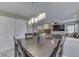 Open-concept dining area with modern light fixture, dark wood table and access to the living room at 5617 Gainesway Dr, Greenwood, IN 46142