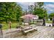 Backyard deck with picnic table, benches, and lush greenery creating an inviting outdoor space at 5750 W 650 N, Thorntown, IN 46071