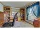 Bright home office featuring custom built-in wooden shelving, a large window and neutral carpet at 5750 W 650 N, Thorntown, IN 46071
